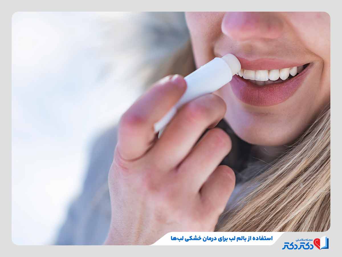 زن در حال استفاده از بالم لب برای درمان خشکی لب
